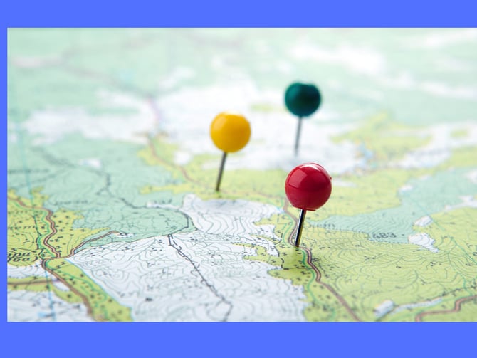 Colored pushpins marking locations on a topographic map