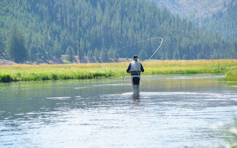 Man fishing on a river.